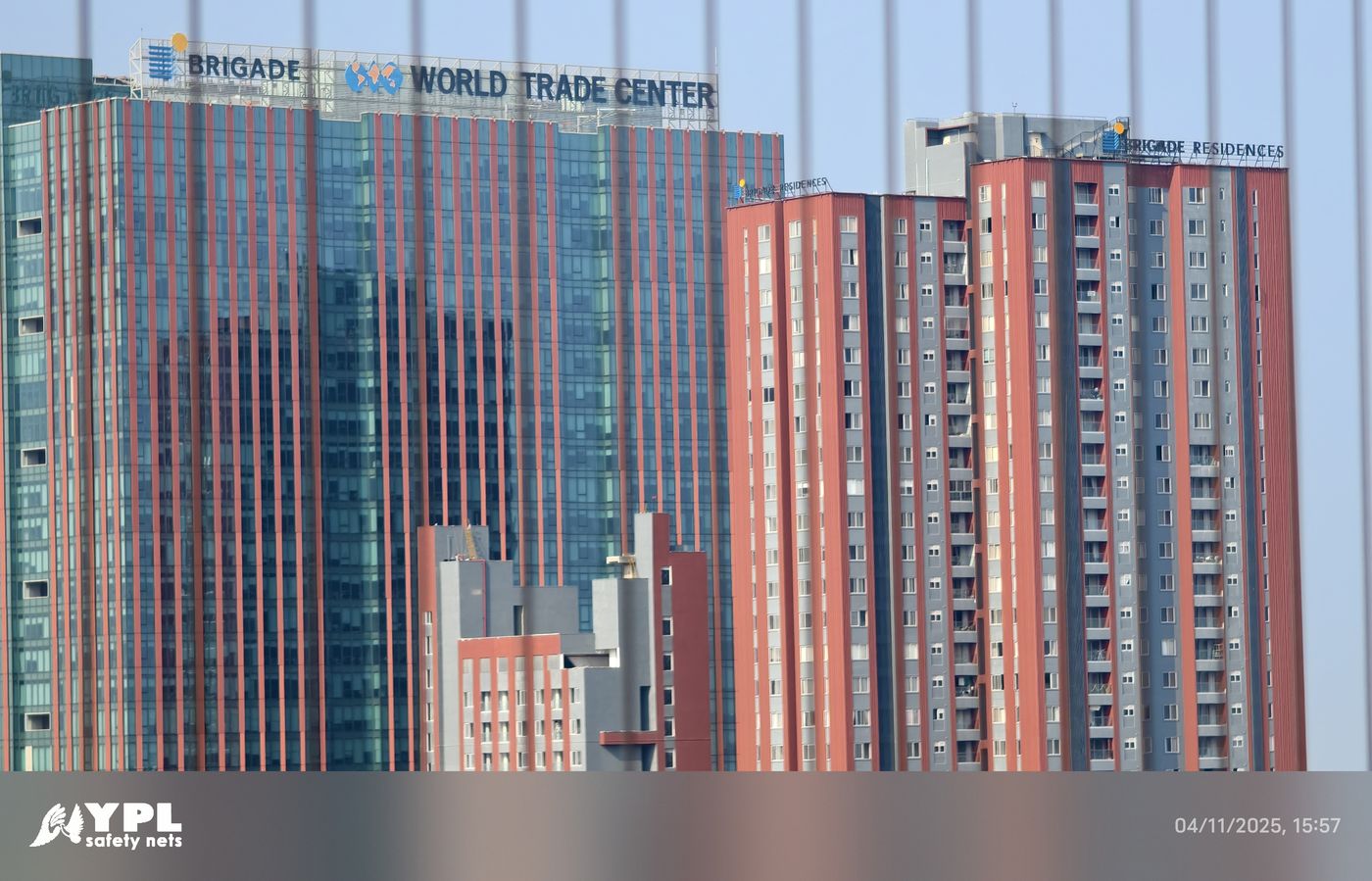 World Trade Center and neighboring residential towers viewed through vertical invisible grill wires.